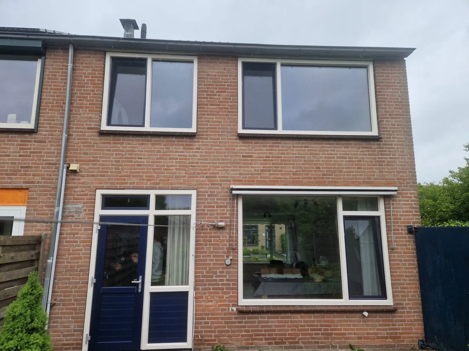 Rijwoning met crèmewitte kozijnen en een blauwe deur