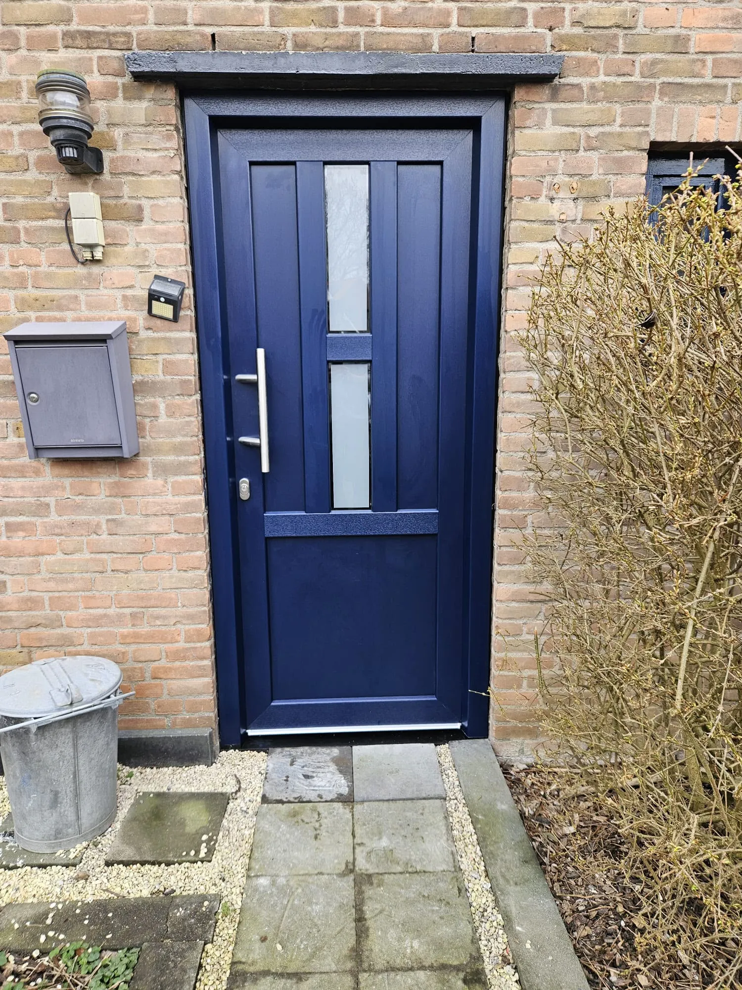 Donkerblauwe voordeur met glasstroken